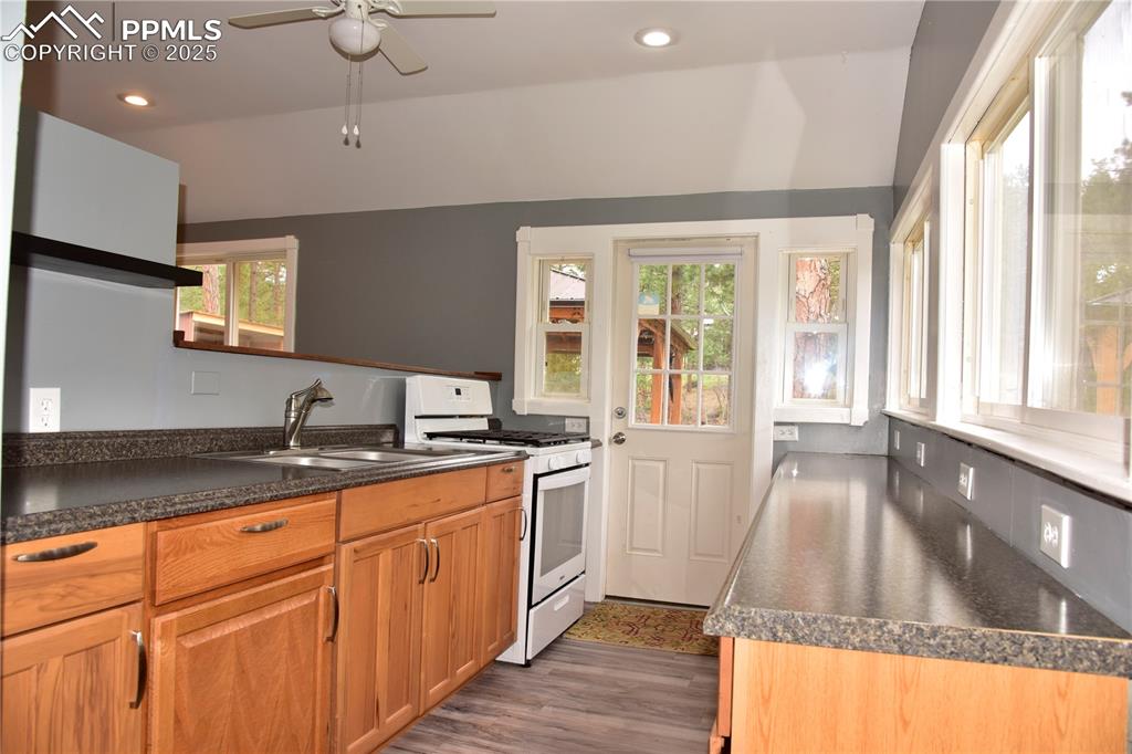 Image 11 of 46: Kitchen featuring white range with gas cooktop, a sink, healthy amount of n