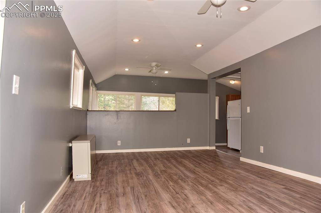 Image 5 of 46: Unfurnished room with a ceiling fan, lofted ceiling, wood finished floors,