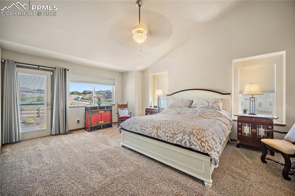 Image 12 of 50: Primary bedroom with vaulted ceilings and walkout to back yard. 