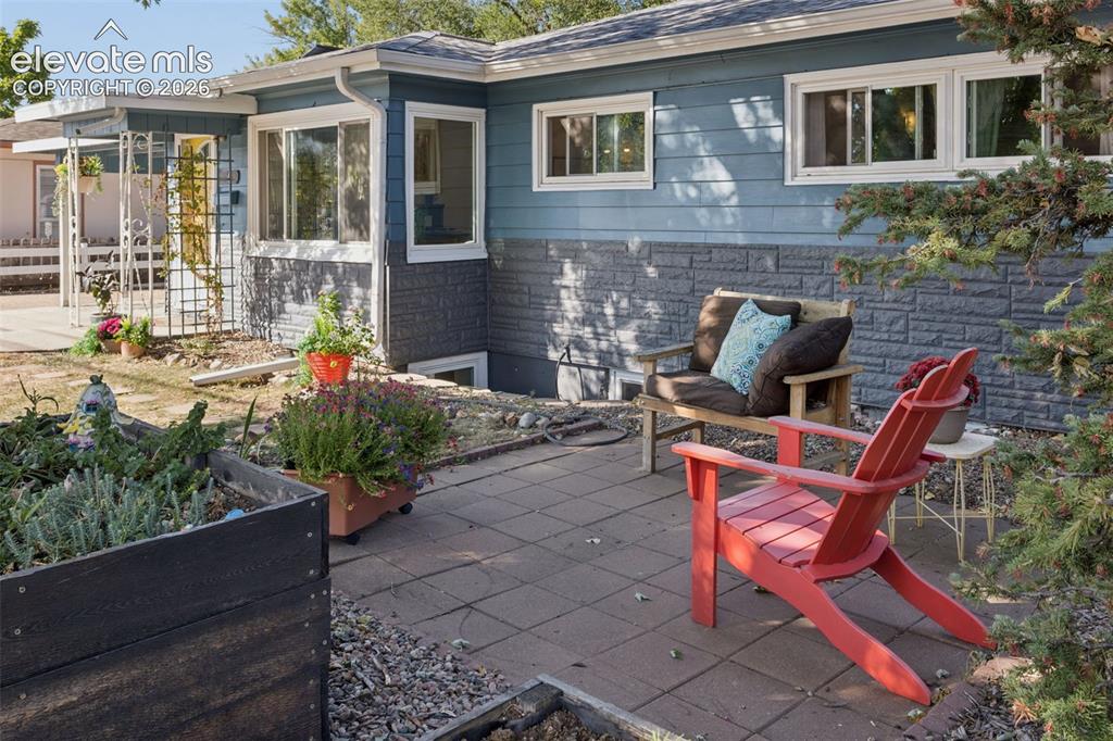 Caption: Exterior with blue siding and a grey stone-finish foundation