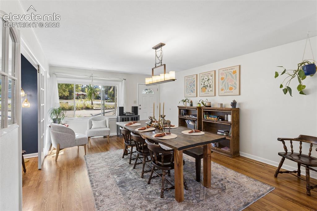 Image 11 of 50: Wood-finish flooring, white walls, and a large front-facing window