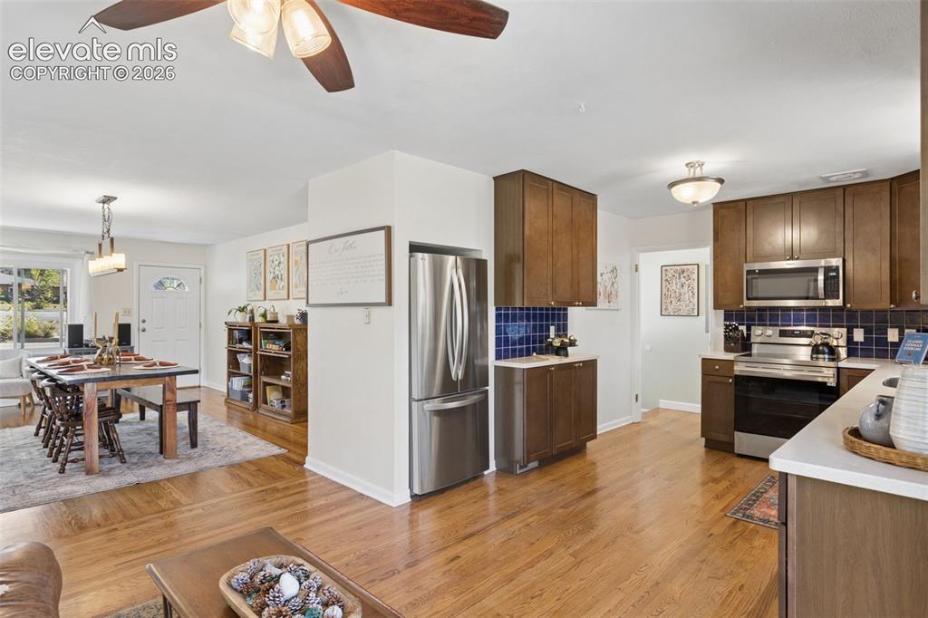 Image 14 of 50: Hardwood flooring throughout, kitchen with wood-finish cabinetry, stainless