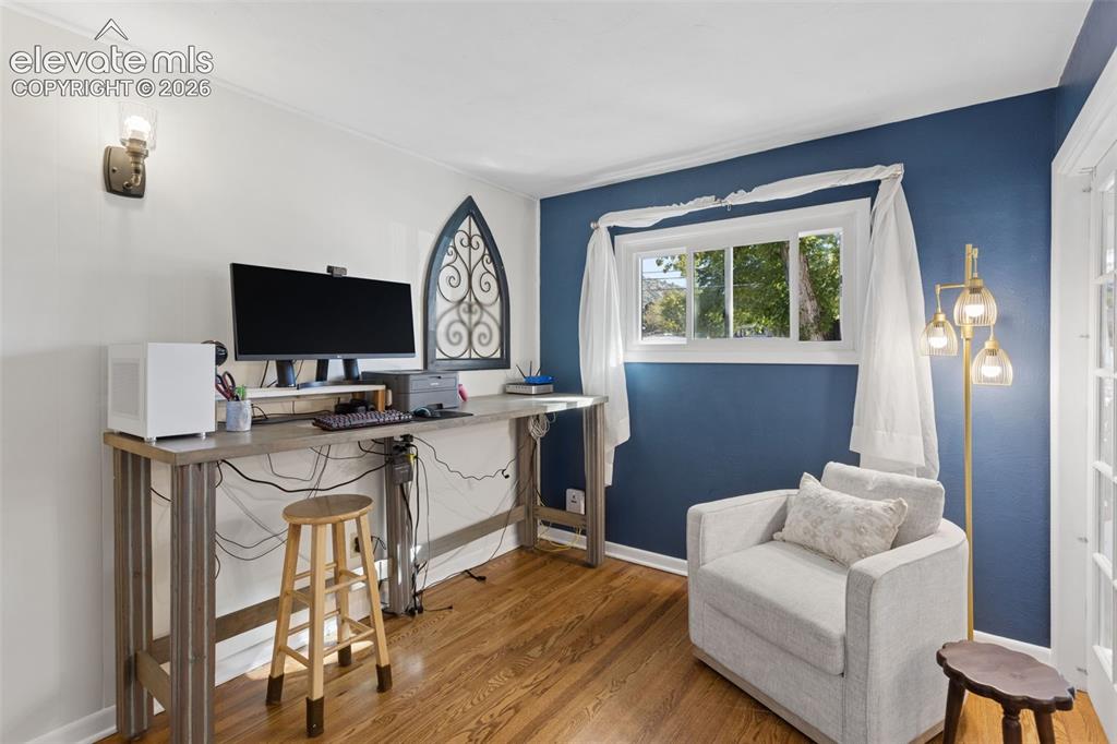 Image 19 of 50: Hardwood flooring, white wall paint, a single window, a wall-mounted light 