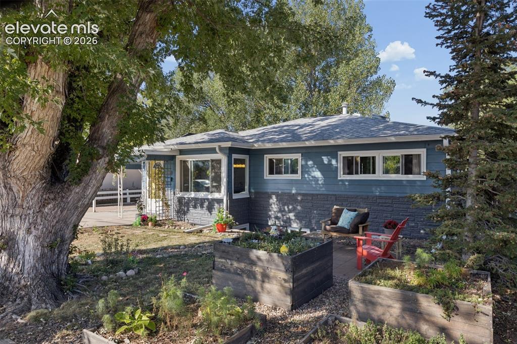 Image 2 of 50: Blue siding with a stone veneer foundation, asphalt shingle roofing, multip