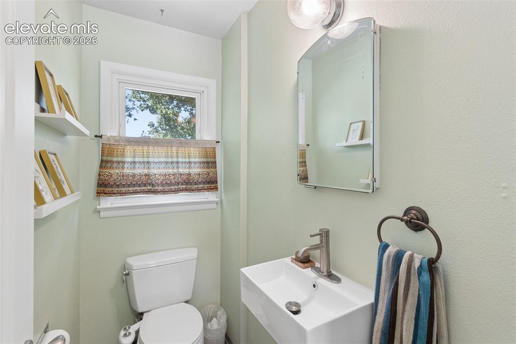 Image 20 of 50: Wall-mounted rectangular sink with a single-handle faucet, arched mirror, a