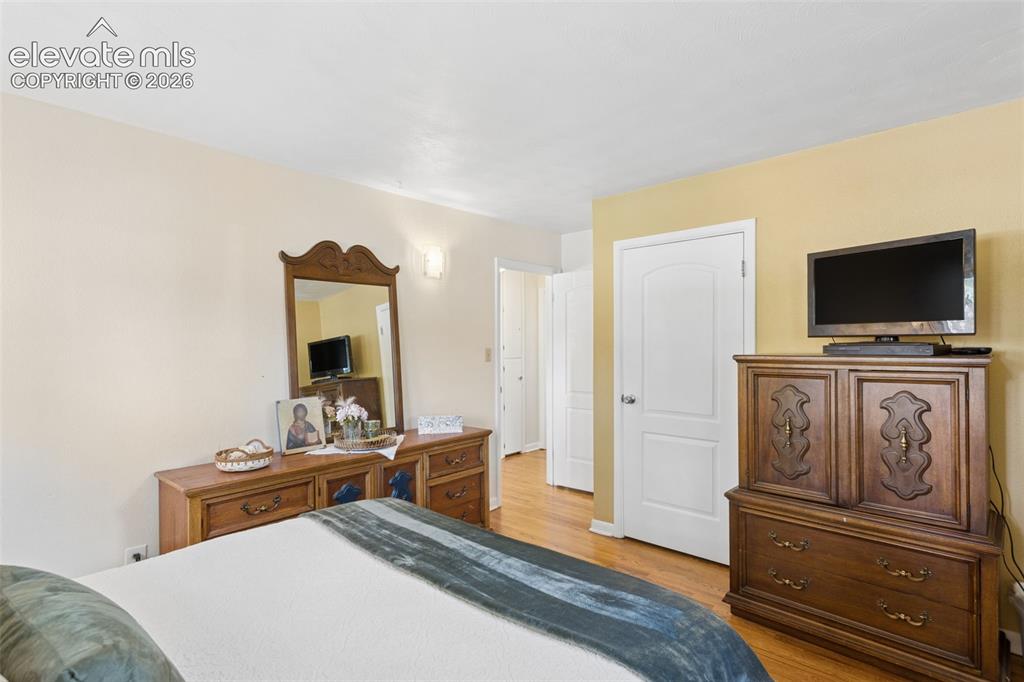 Image 25 of 50: Wood-finish flooring, white interior doors with curved paneling, and an ove