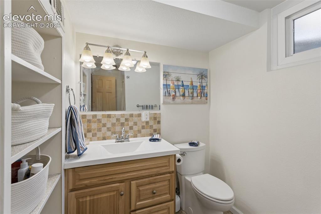 Image 37 of 50: Wood-finish vanity with a white countertop and integrated sink