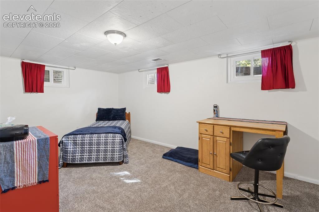 Image 39 of 50: Neutral wall paint, textured ceiling panels, flush mount ceiling light fixt