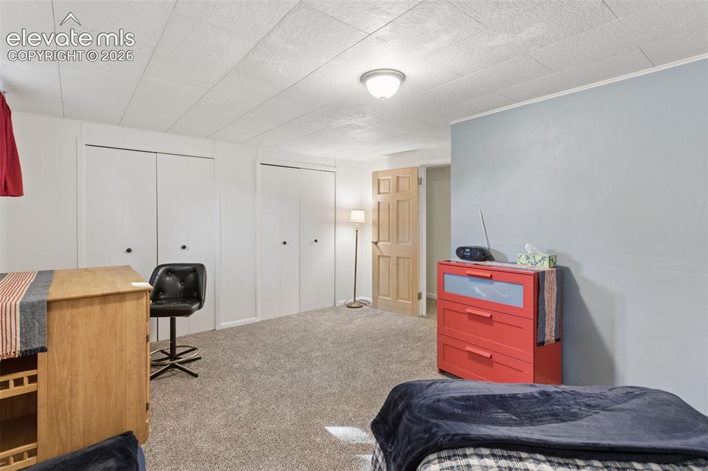 Image 40 of 50: Textured ceiling, wall-to-wall carpeting, and two sets of bi-fold closet do