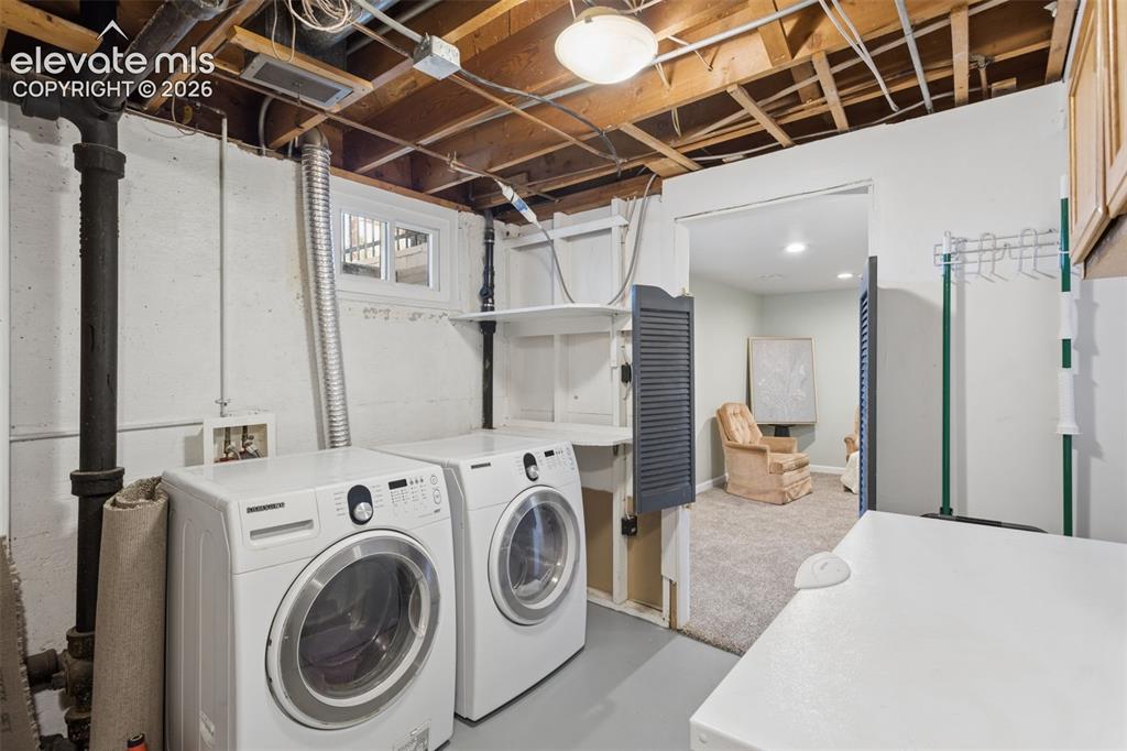 Image 42 of 50: Laundry area featuring a washbasin, exposed ceiling joists, and a utility w