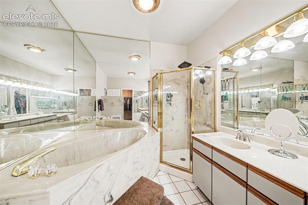 Image 17 of 31: Expansive main bathroom featuring a built-in tub a separate glass-enclosed 