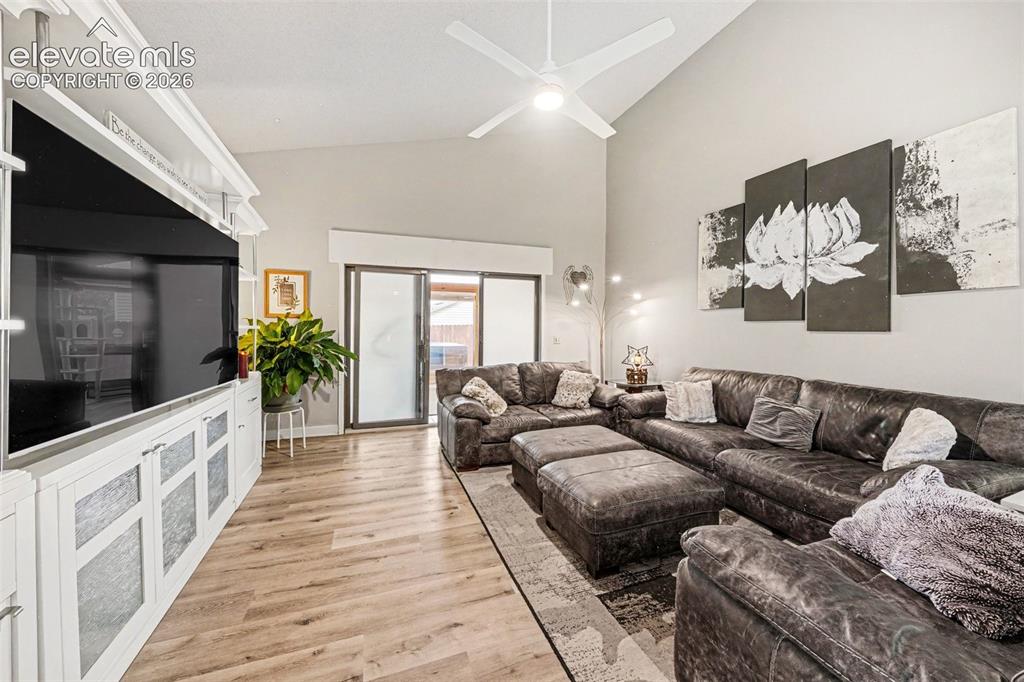 Image 2 of 31: Living room featuring vaulted ceilings, engineered wood-finish flooring, an