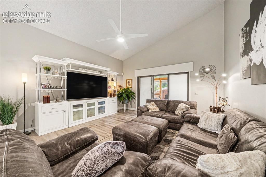 Image 3 of 31: Vaulted ceiling in the expansive living area, a media console with shelving