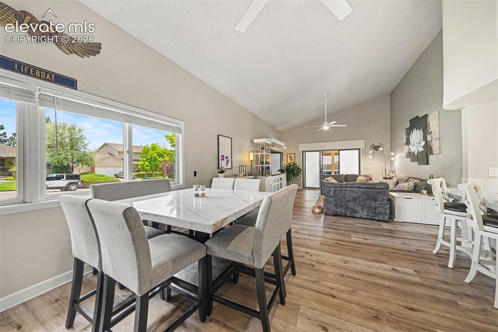 Image 4 of 31: Open-concept living space featuring vaulted ceilings, wood-finish flooring,