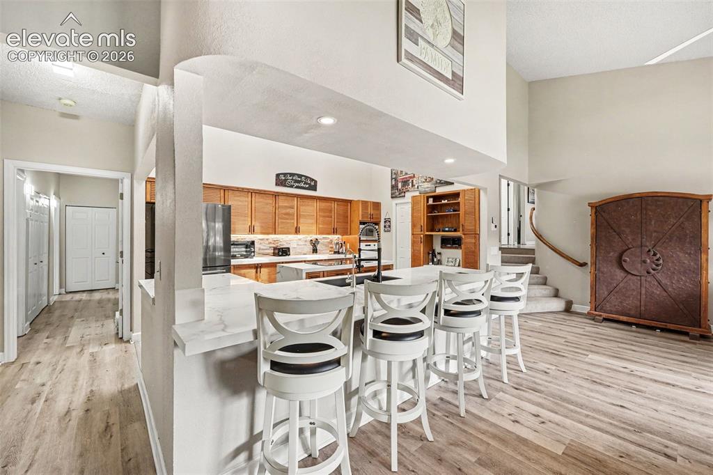 Image 8 of 31: Open-concept kitchen with a breakfast bar convenient pop-up plugs, featurin