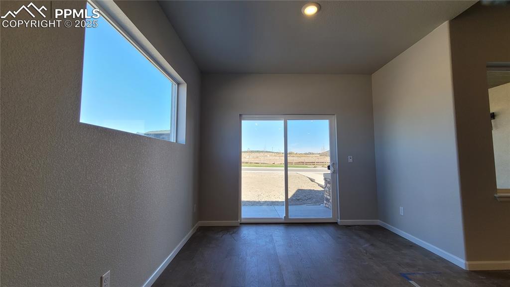 Image 12 of 36: Dining area with engineered wood flooring, natural light, and sliding glass