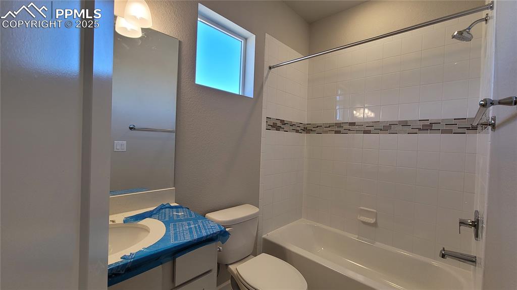 Image 26 of 36: Full Bathroom with quartz countertop and tile surrounds! Please, excuse our