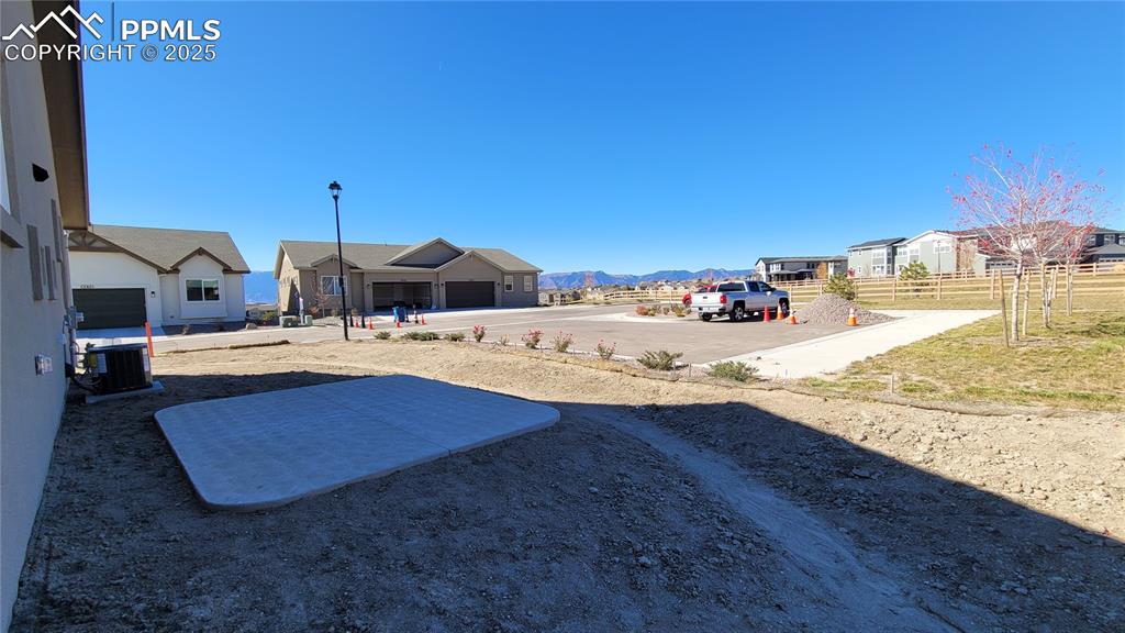 Image 6 of 36: Side Yard with large patio to enjoy! Please, excuse our dust as this home i