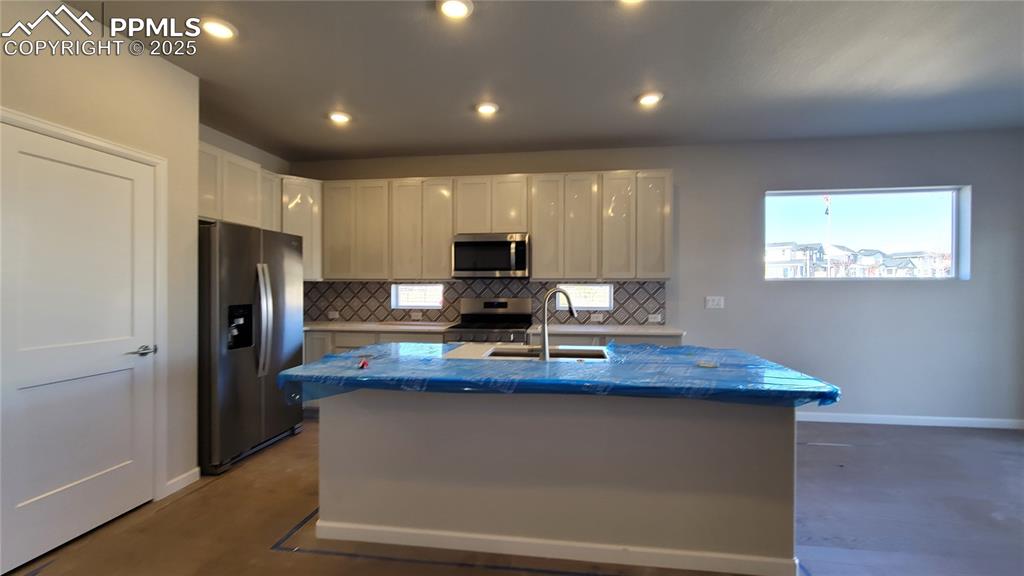 Image 9 of 36: Kitchen with quartz countertops, pantry, large island providing additional