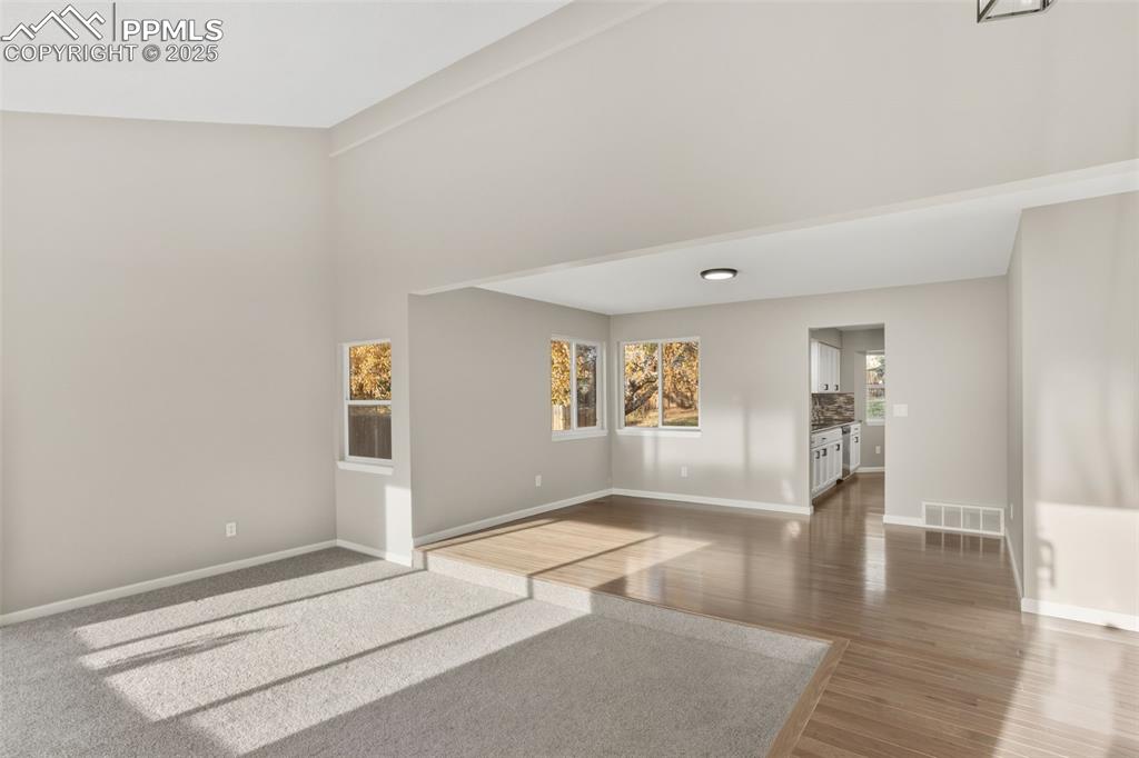 Image 13 of 32: Carpeted Living room, solid hardwood floor in the dining room, hallway and