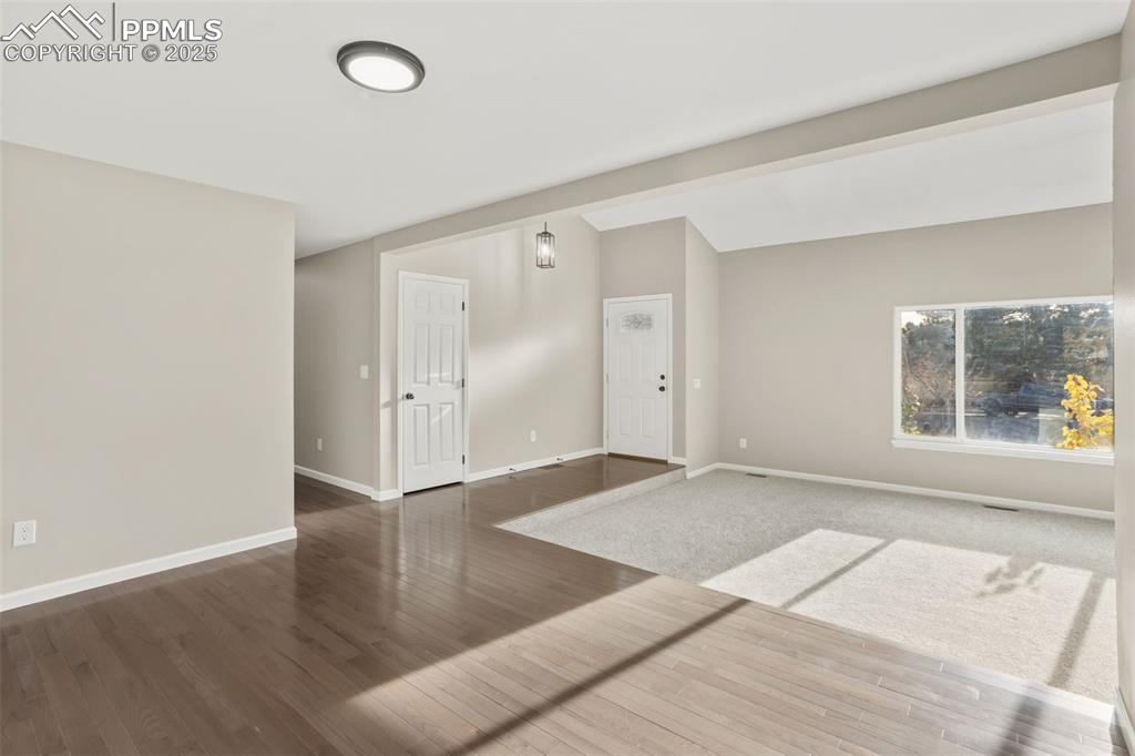 Image 14 of 32: Carpeted Living room, solid hardwood floor in the dining room, hallway and