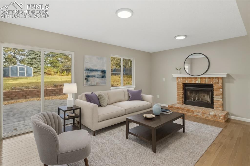 Image 5 of 32: Living room with wood burning fireplace, virtually staged