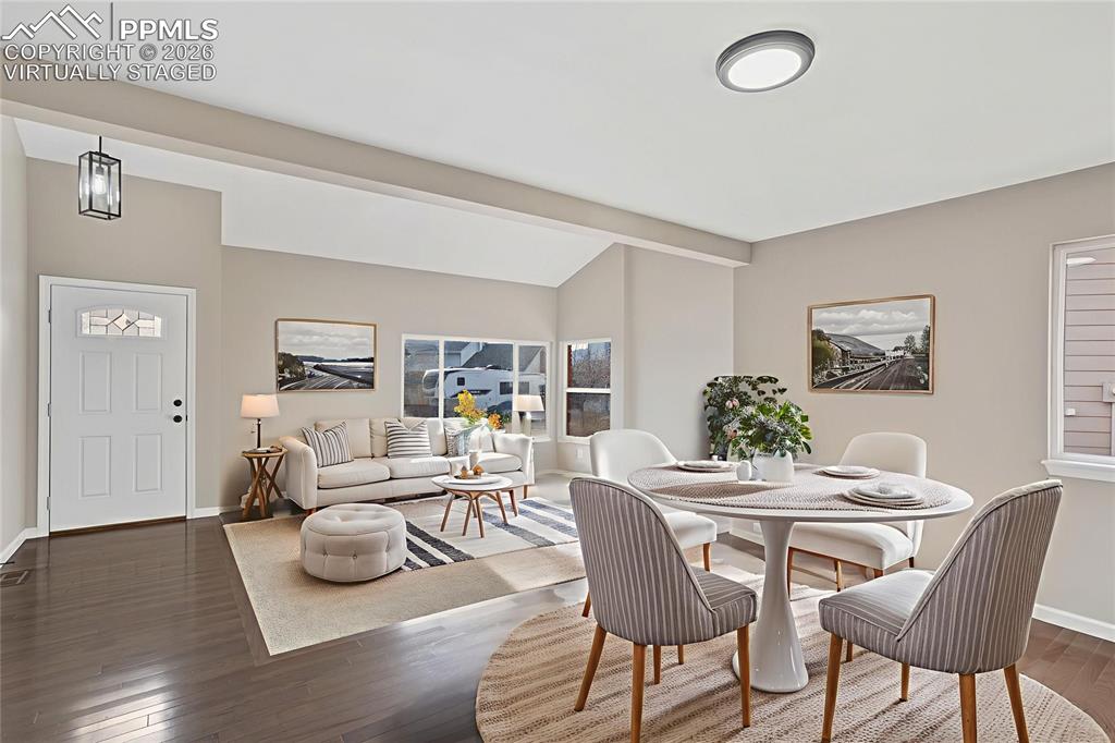 Image 6 of 32: Dining area with dark wood-type flooring and baseboards, "Virtually Staged"