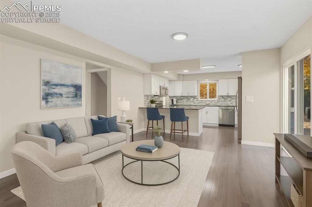 Image 7 of 32: Living room with wood burning fireplace, virtually staged