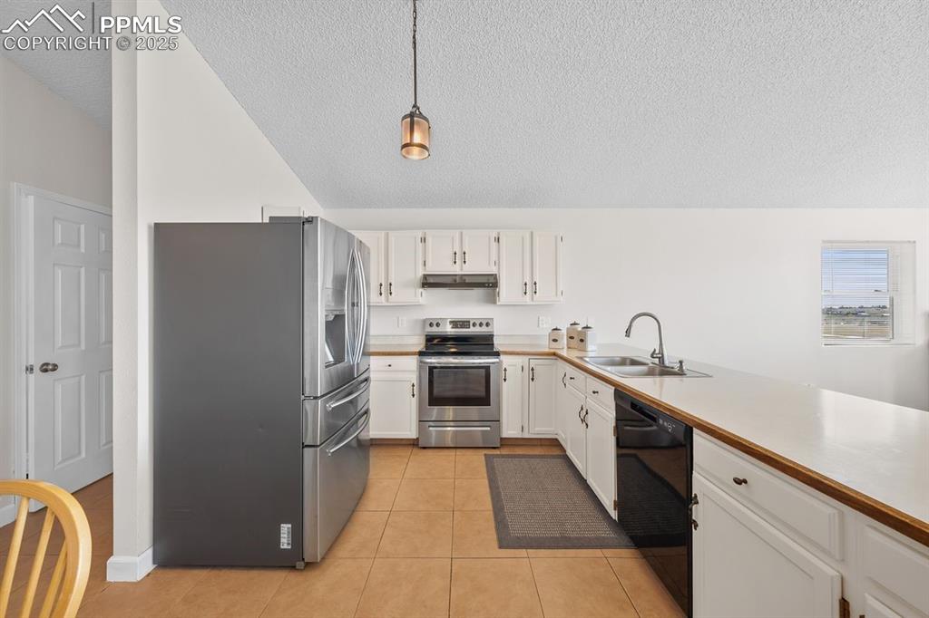 Image 11 of 39: Kitchen featuring appliances with stainless steel finishes, light counterto