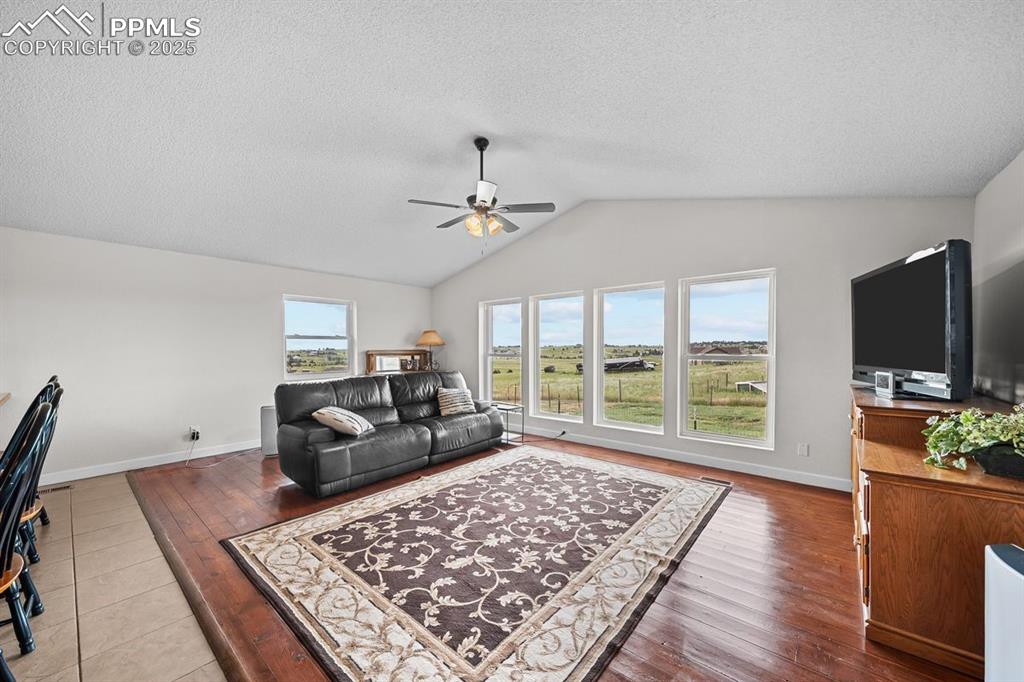 Image 14 of 39: Living room featuring vaulted ceiling, wood floors, southern views and ceil