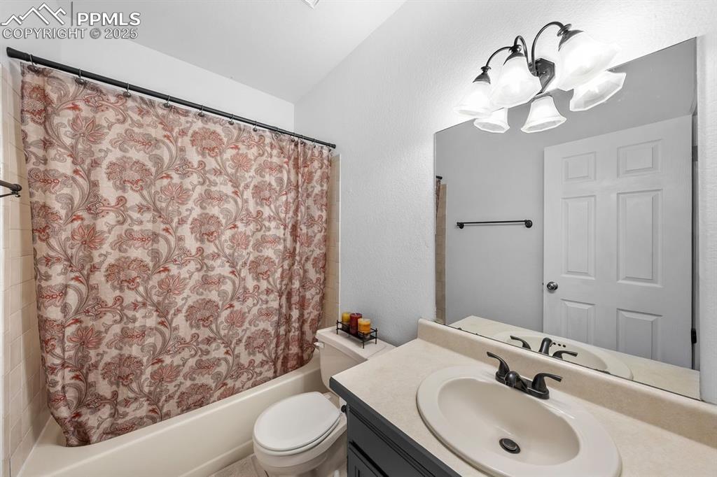 Image 28 of 39: Full bath with shower / bath combo, vanity and chandelier