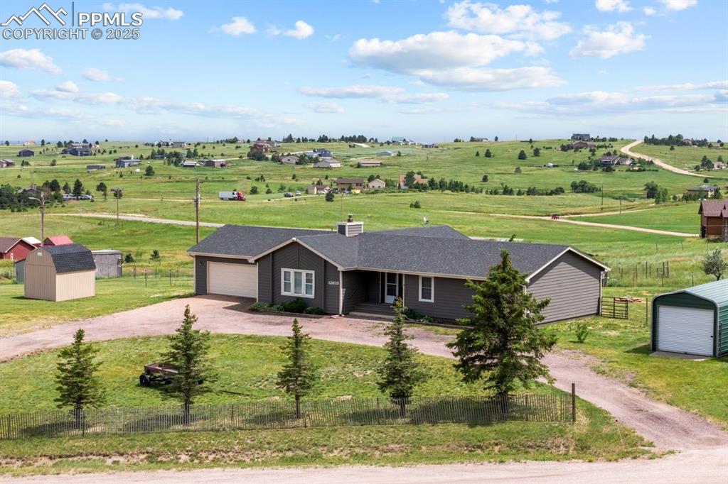 Image 33 of 39: View of front of home with a view of countryside, dirt circular driveway an