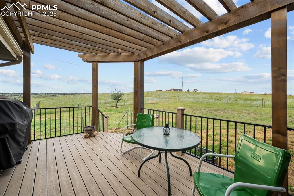 Image 5 of 39: Deck featuring a view of countryside, a grill, a lawn, outdoor dining area,