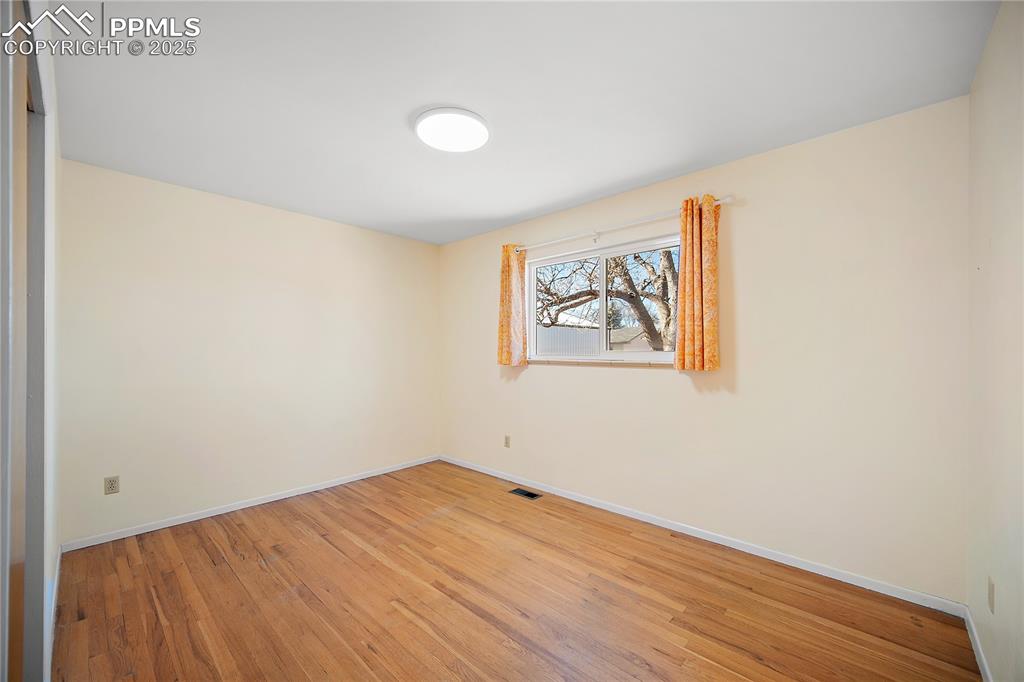 Image 18 of 48: Upper level bedroom 2 also with hardwood flooring and good size closet. 