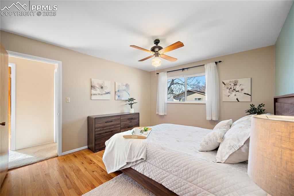 Image 20 of 48: Upper level primary bedroom with hardwood flooring. 
