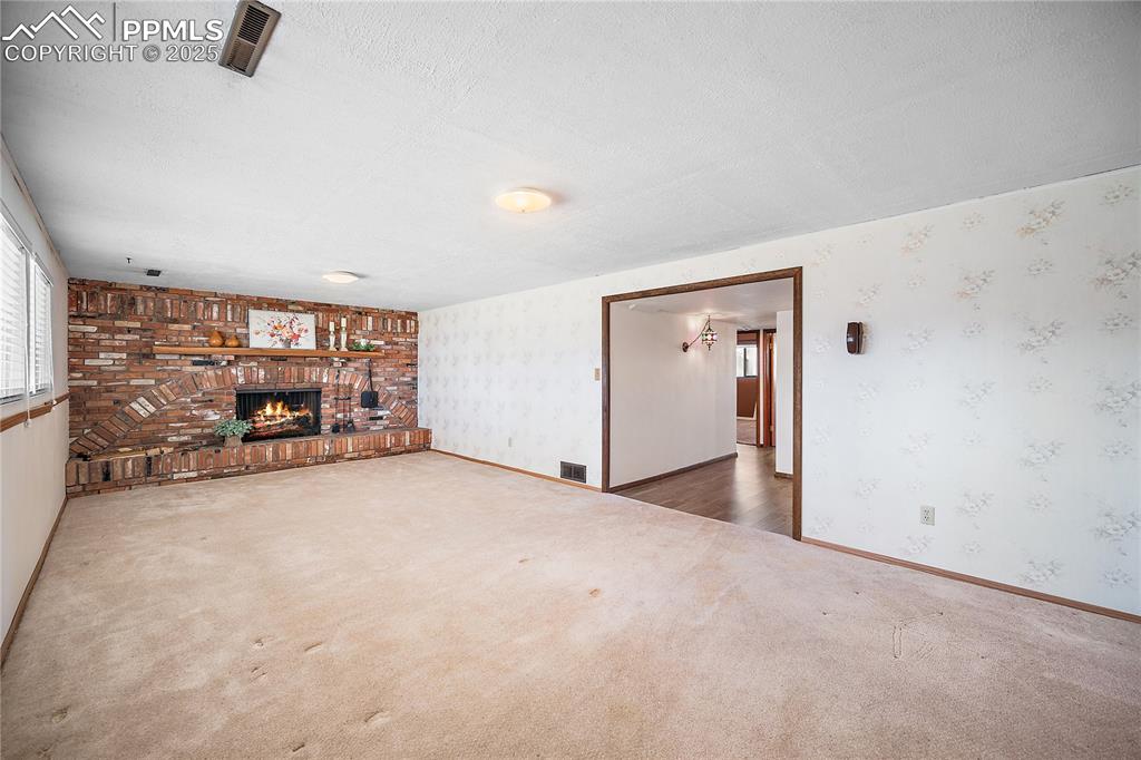 Image 24 of 48: Lower level family/rec room with carpet and wood burning fireplace. 