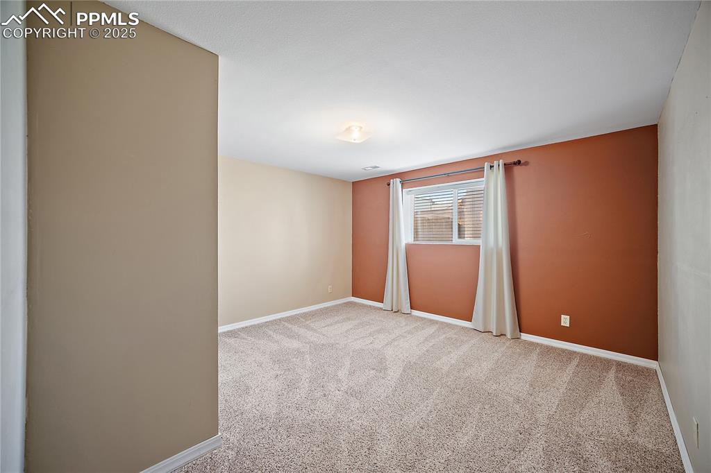Image 30 of 48: Lower leve bedroom 5 with carpet and large closet. 
