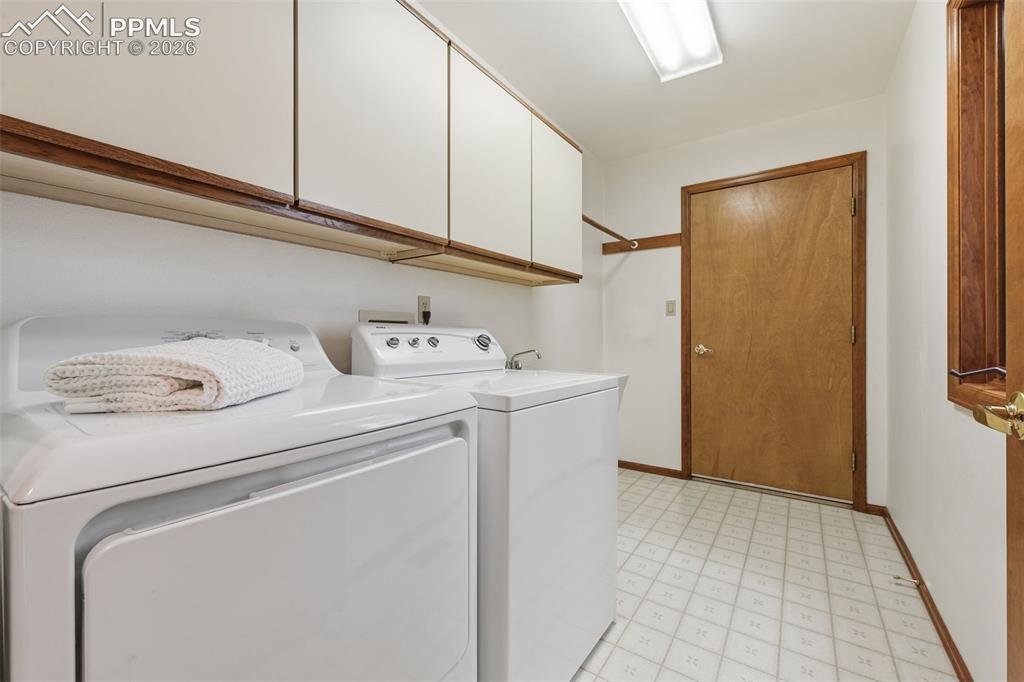 Image 20 of 45: Large laundry room with sink connects to garage
