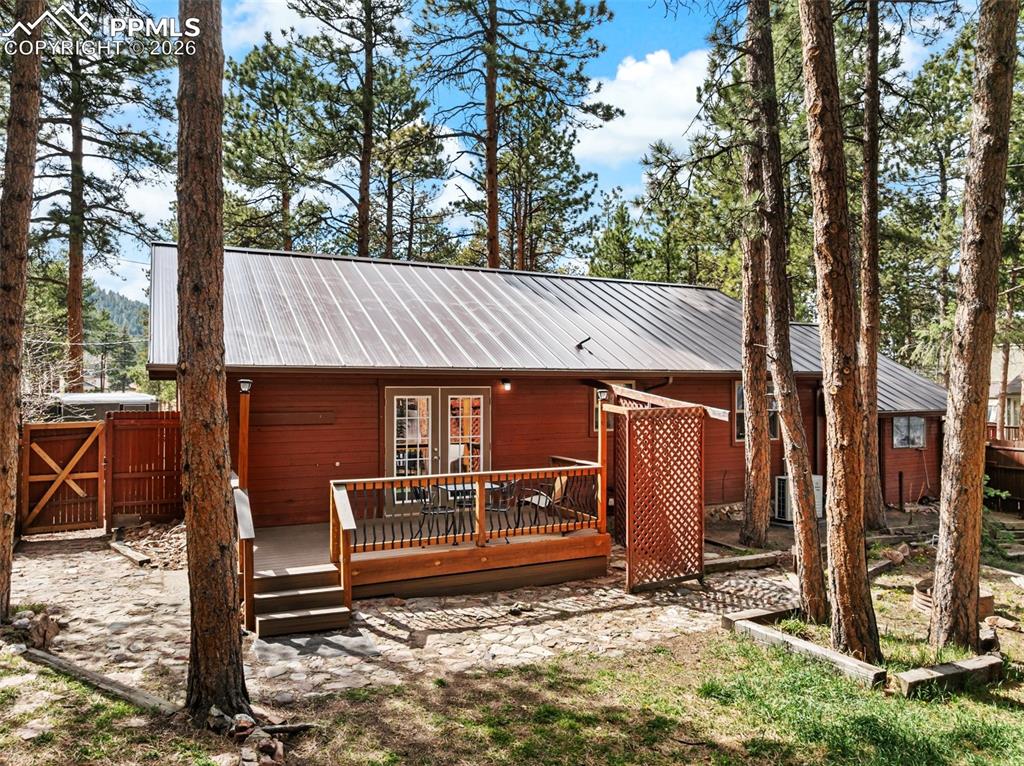 Image 7 of 44: Wood-sided exterior featuring a metal roof and a multi-level deck with wood