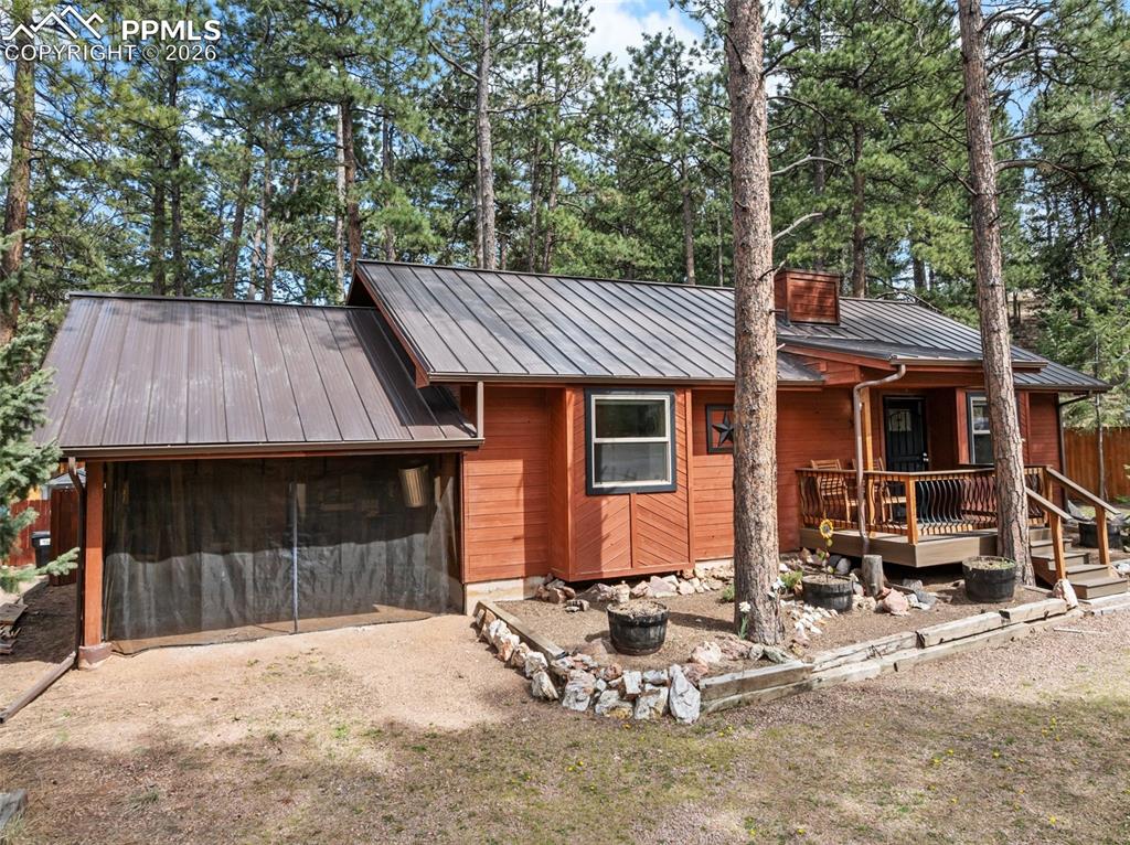 Image 8 of 44: Cedar-sided exterior with a metal roof