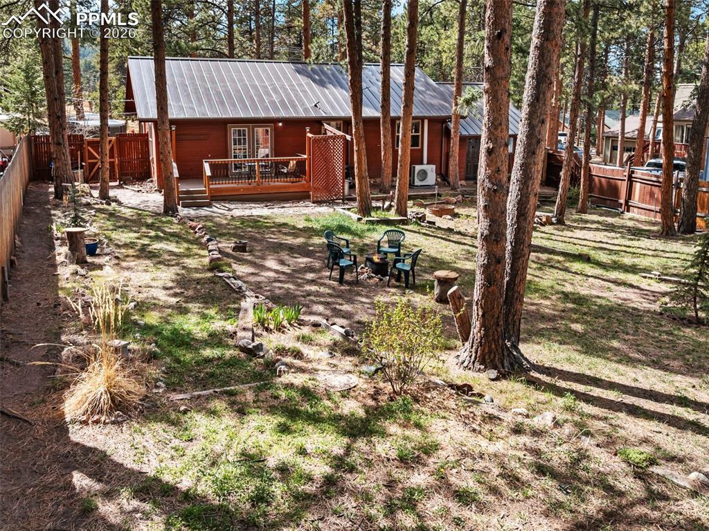 Image 9 of 44: Wood-sided residence with a metal roof and a rear deck
