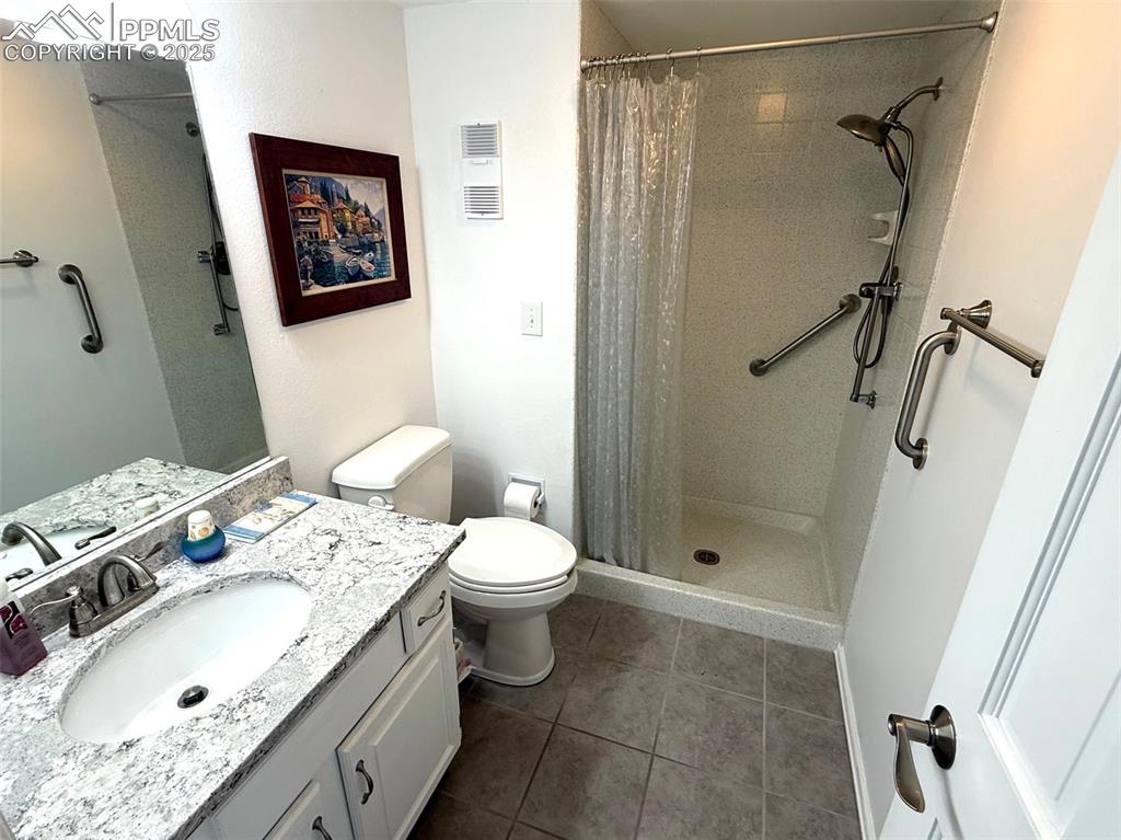 Image 11 of 11: Bathroom featuring a stall shower, vanity and tile flooring