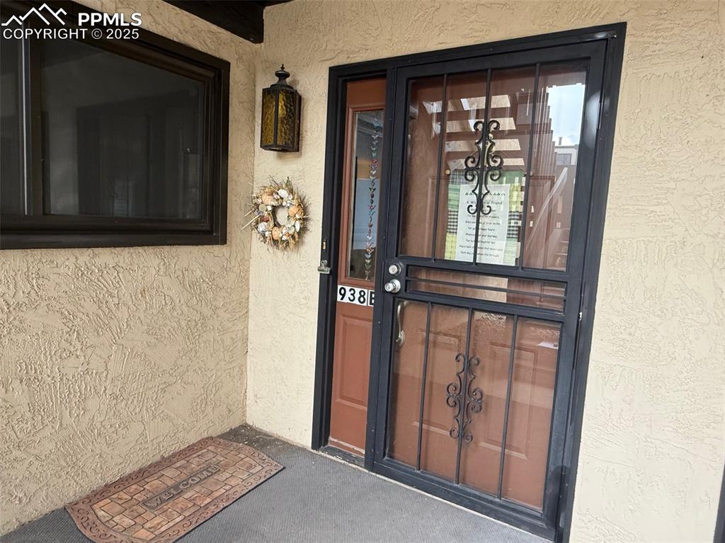 Image 2 of 11: Doorway to property featuring stucco siding