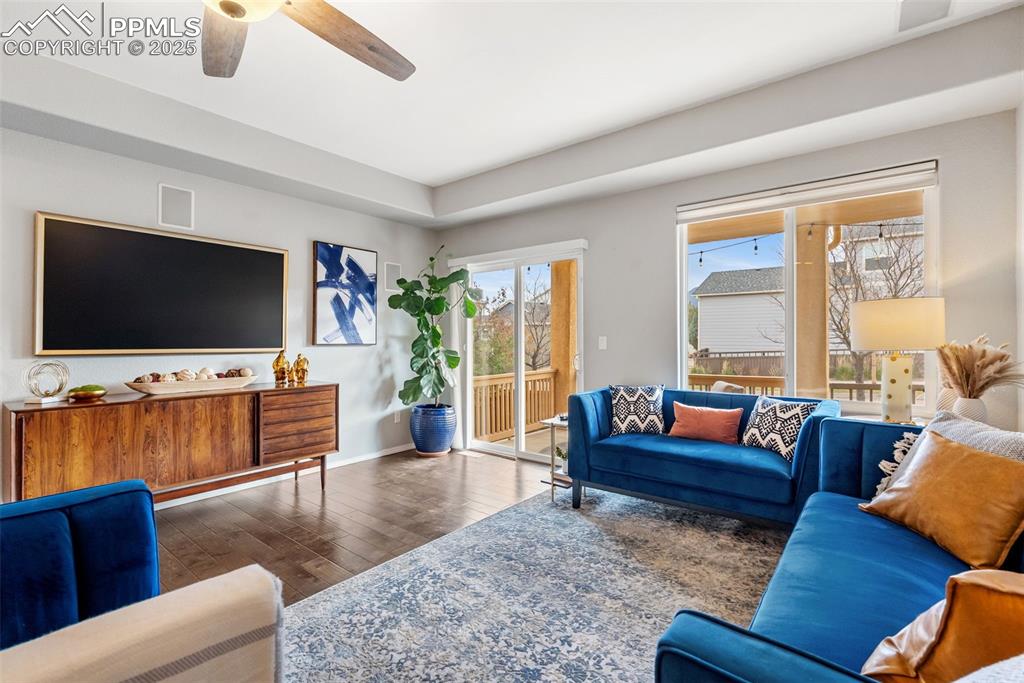 Image 12 of 50: Living room with wood-type flooring and a ceiling fan