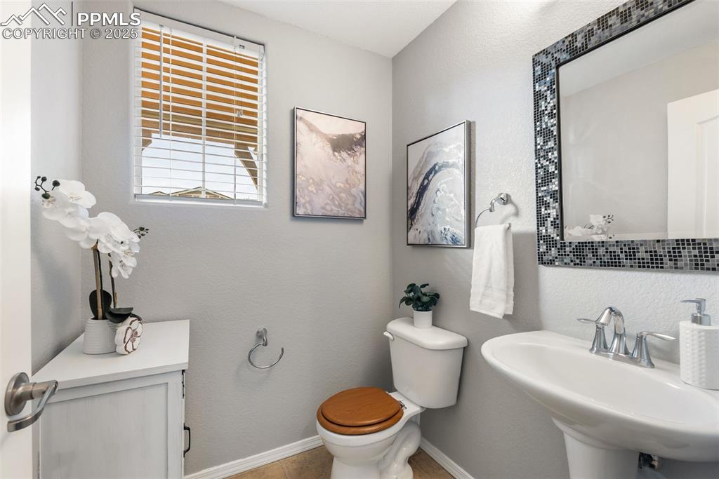 Image 15 of 50: Half bath with a textured wall and tile patterned floors