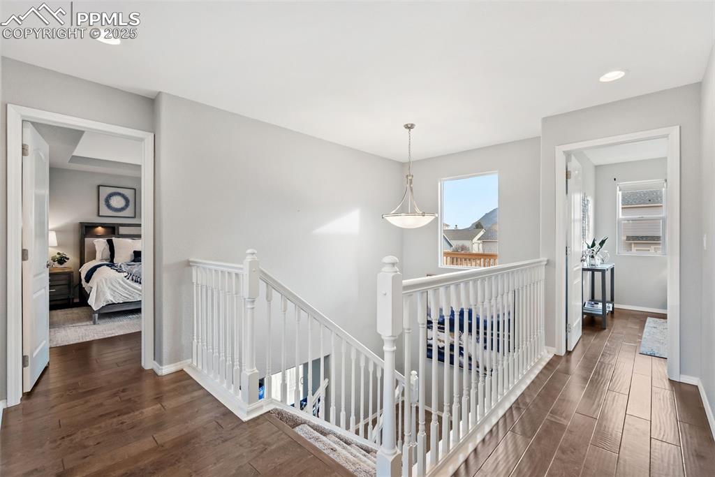 Image 19 of 50: Corridor featuring an upstairs landing, dark wood-style flooring, and reces