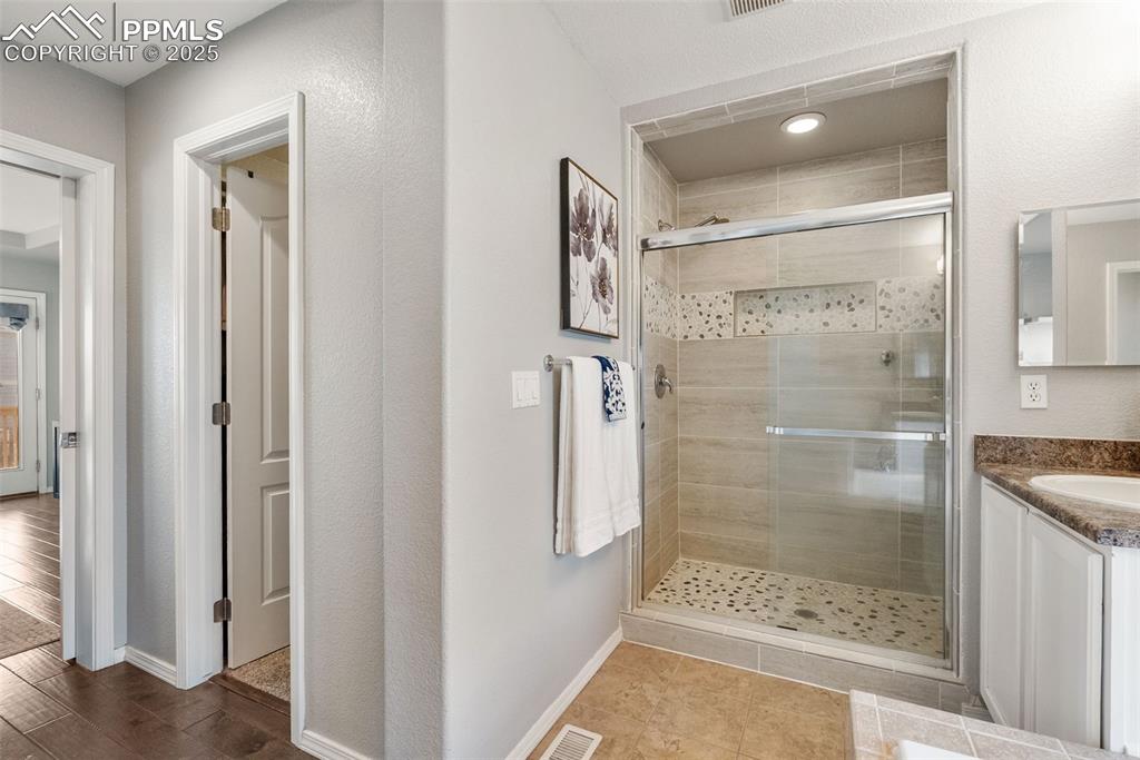Image 25 of 50: Bathroom with a stall shower and vanity