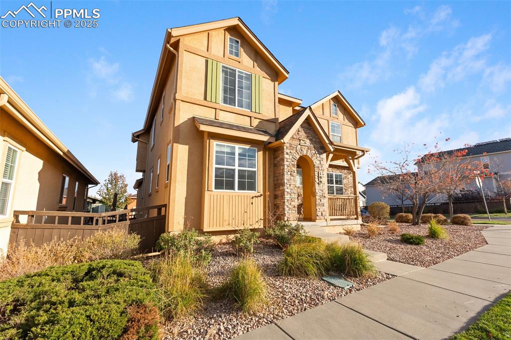 Image 3 of 50: View of front of home featuring stone siding, stucco siding, and covered po