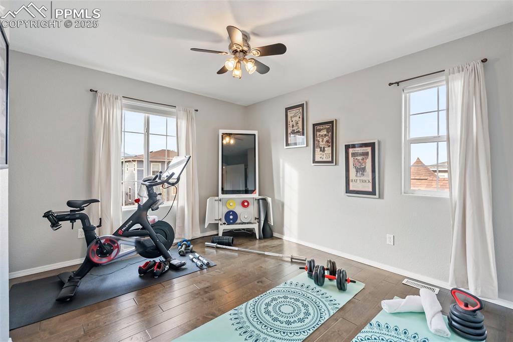 Image 30 of 50: Exercise room featuring wood-type flooring and ceiling fan