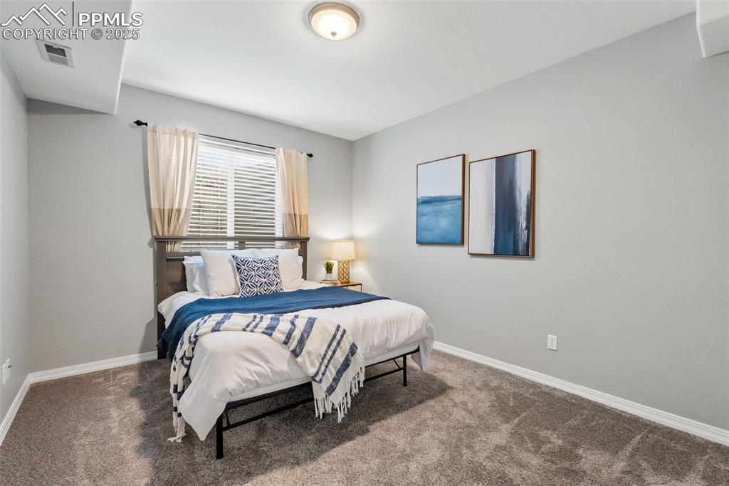 Image 37 of 50: Bedroom with carpet floors and baseboards